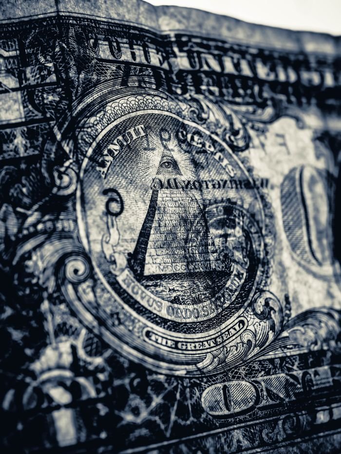 Detailed close-up of the Eye of Providence pyramid on an American dollar bill, symbolizing financial concepts.